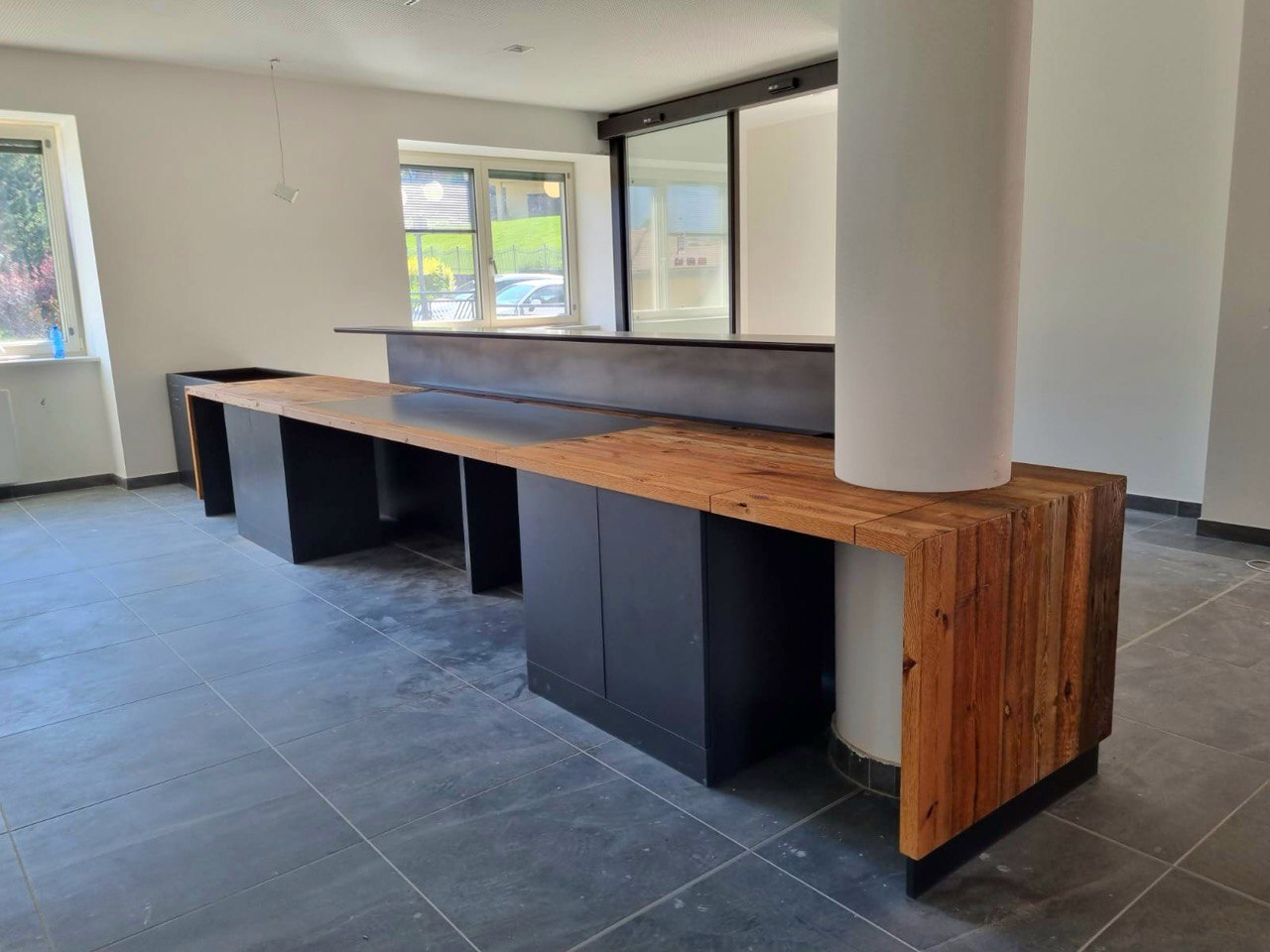 Bancone reception su misura in colorazione nero e legno, collaborazione con un designer di interni